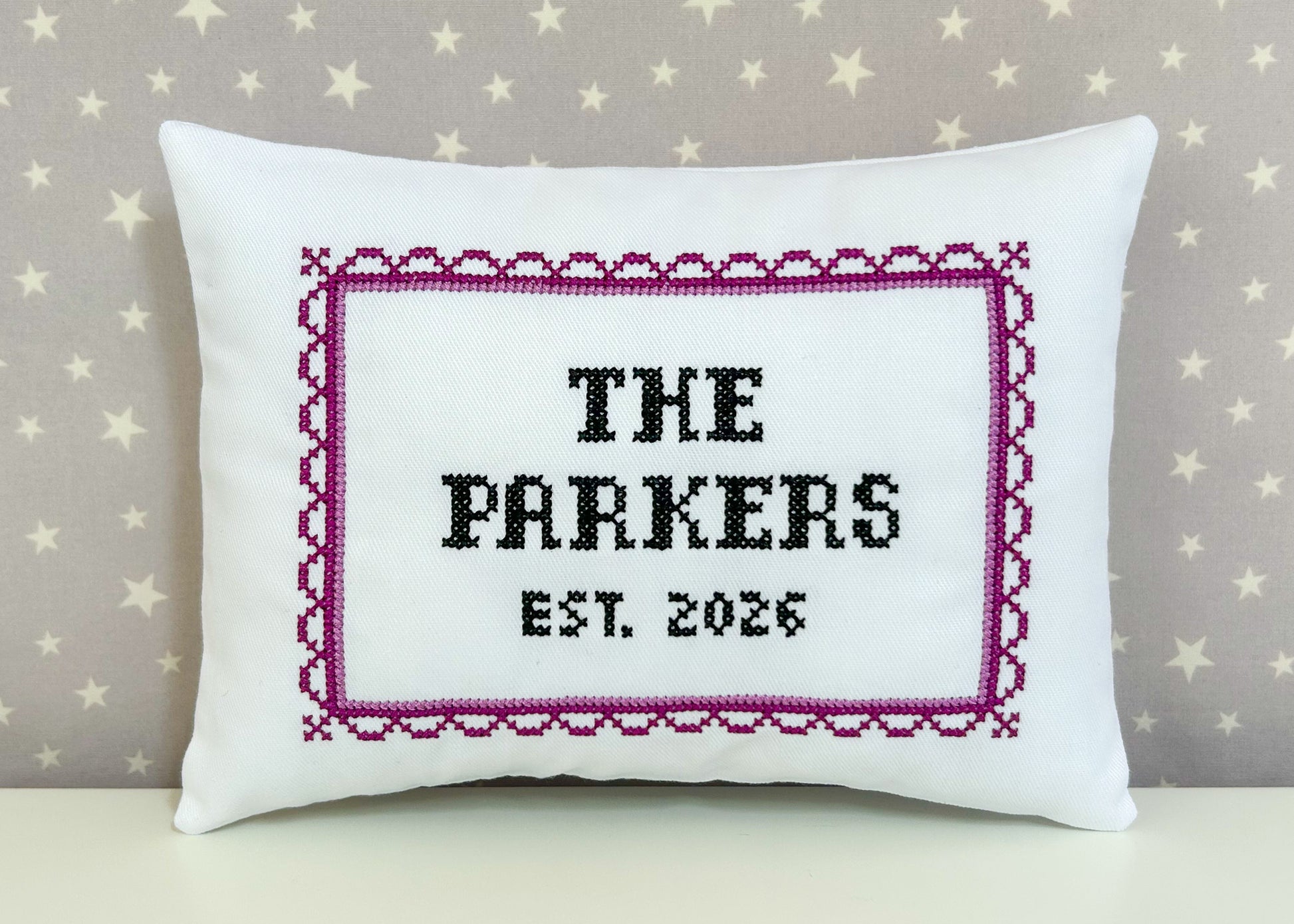 Decorative pillow with 'The Parkers Est. 2026' text on a star-patterned background