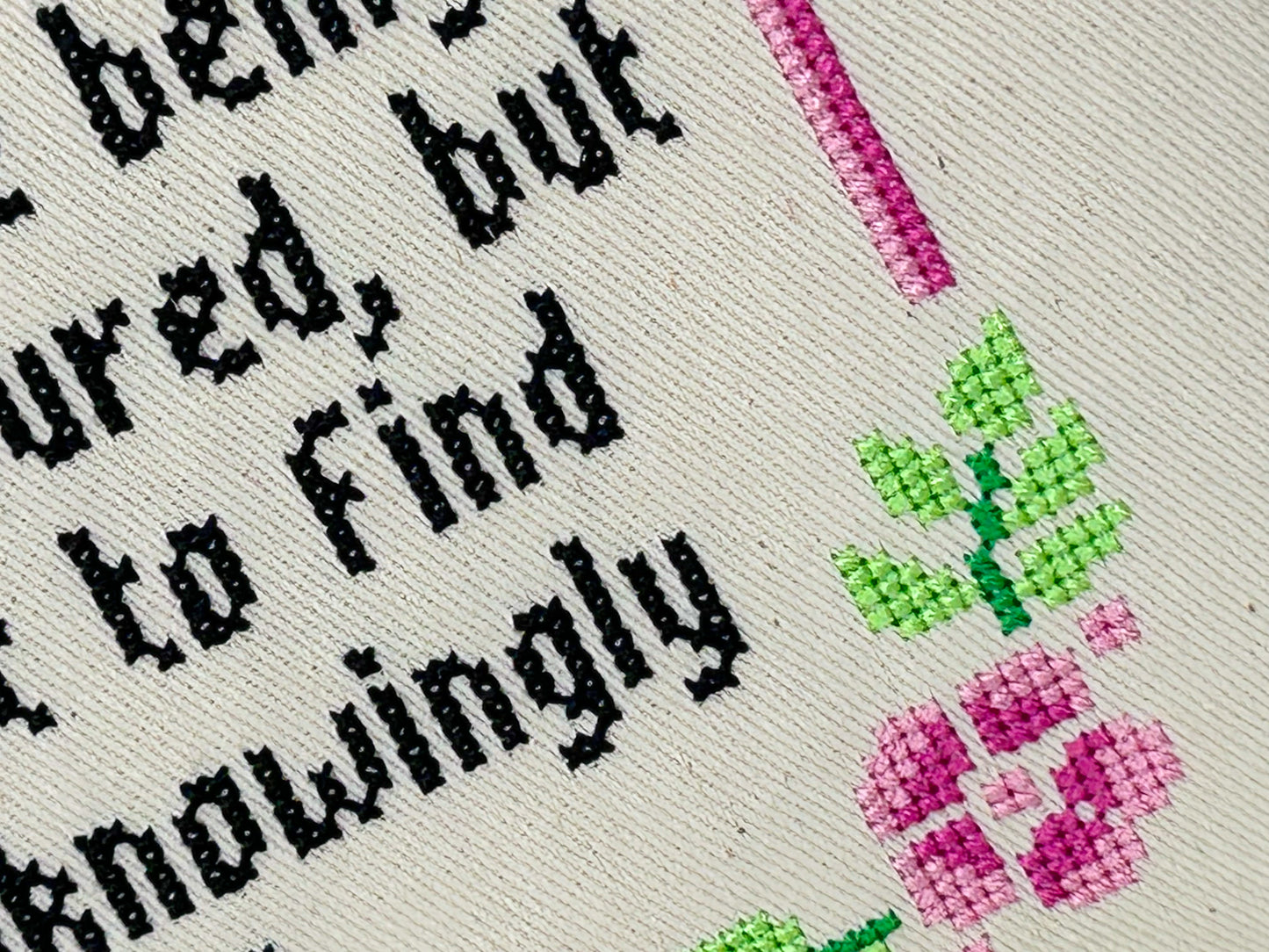 Cross-stitched text with flowers on fabric