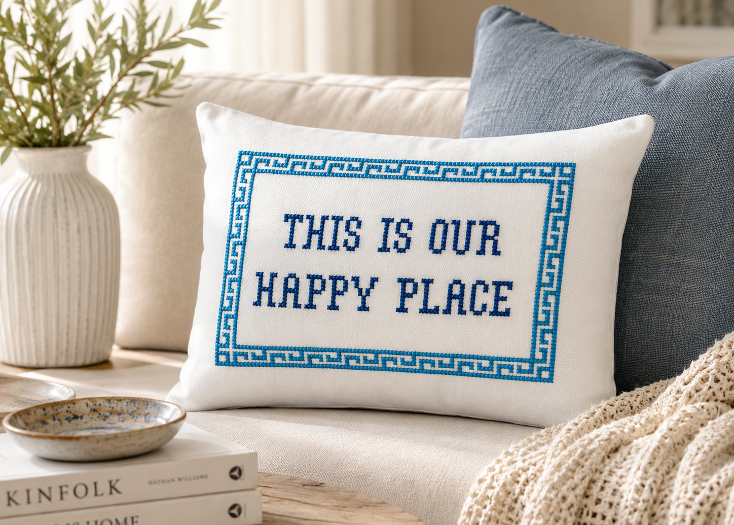 Decorative pillow with 'This is our happy place' text on a couch in a cozy living room.