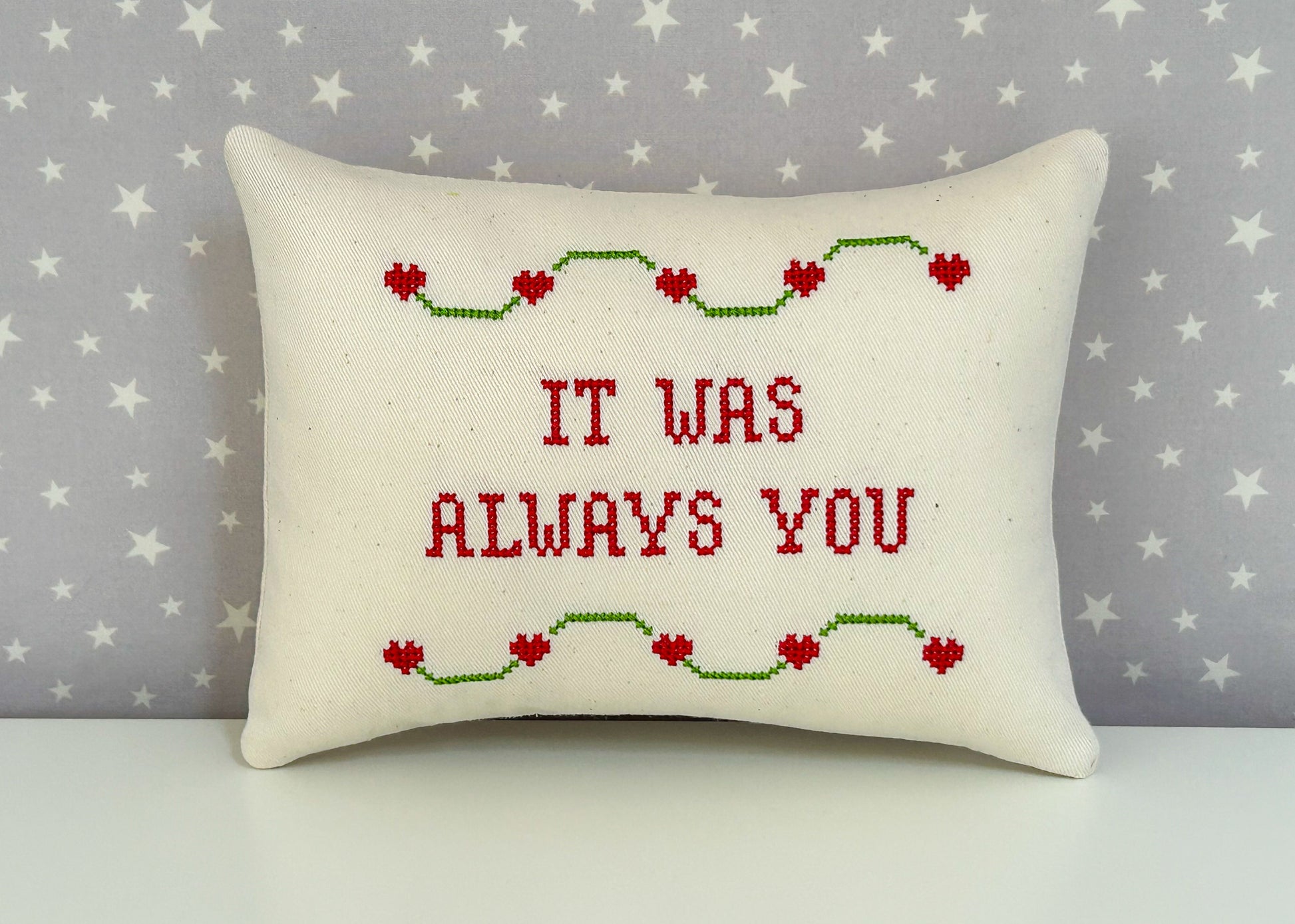 Decorative pillow with 'IT WAS ALWAYS YOU' text on a star-patterned background