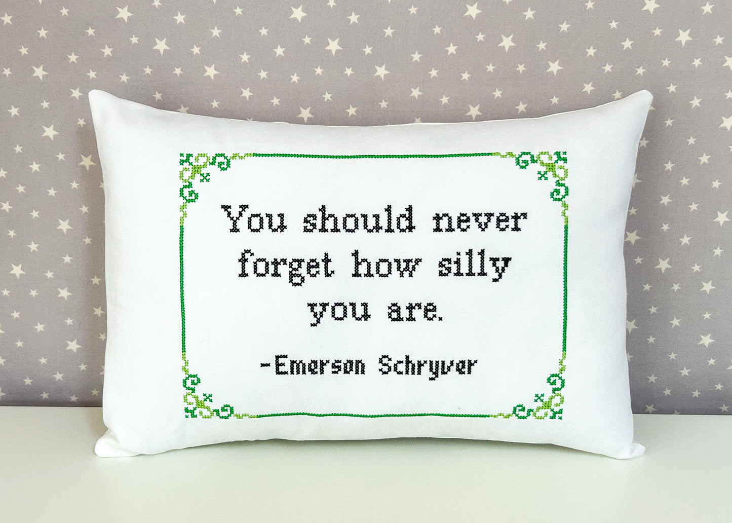 White pillow with a printed quote on a star-patterned background