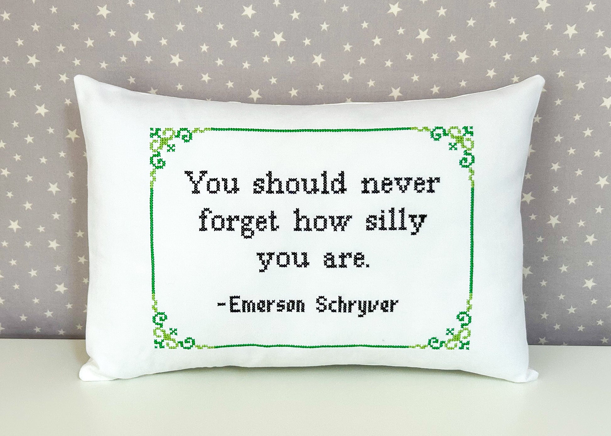 White pillow with a printed quote on a star-patterned background
