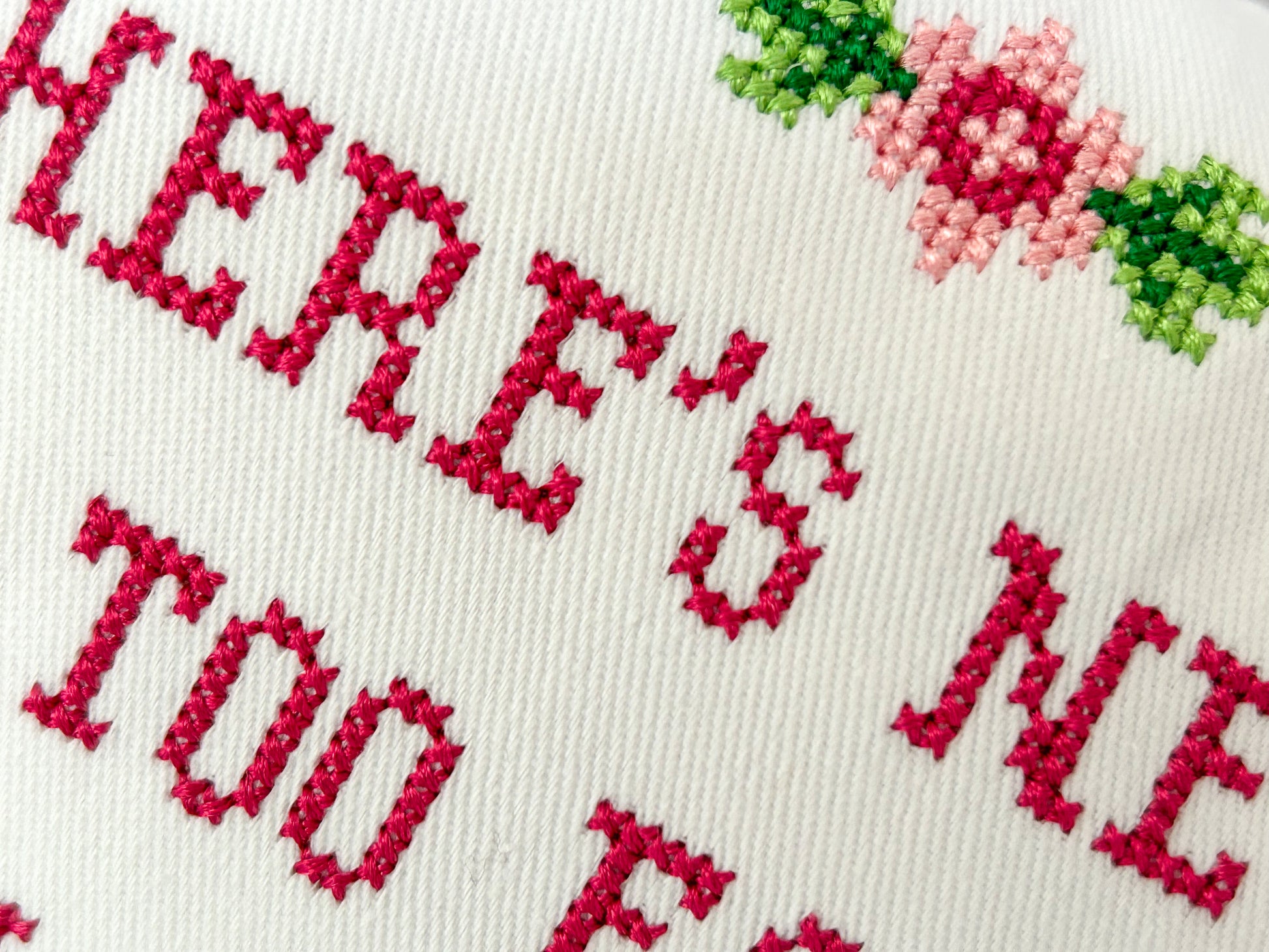 Embroidered text with floral patterns on a white background