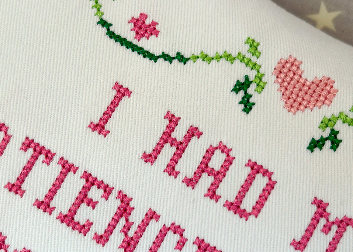 Embroidered text with decorative elements on a white background