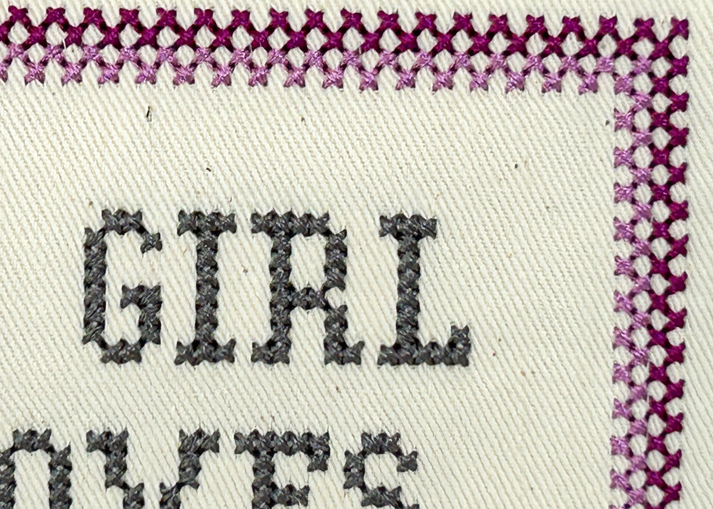 Text 'GIRL DRESSES' on fabric with decorative border