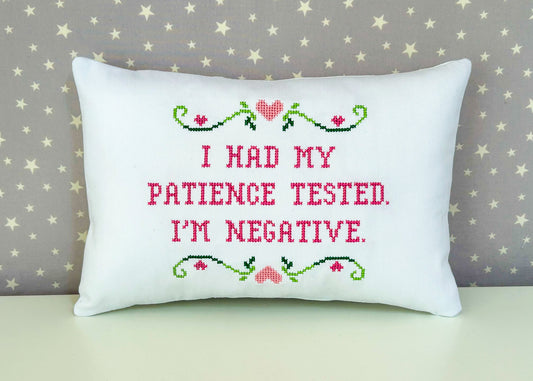 Decorative pillow with cross-stitched text and design on a star-patterned background