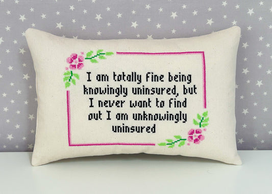 Decorative pillow with cross-stitched text on a star-patterned background