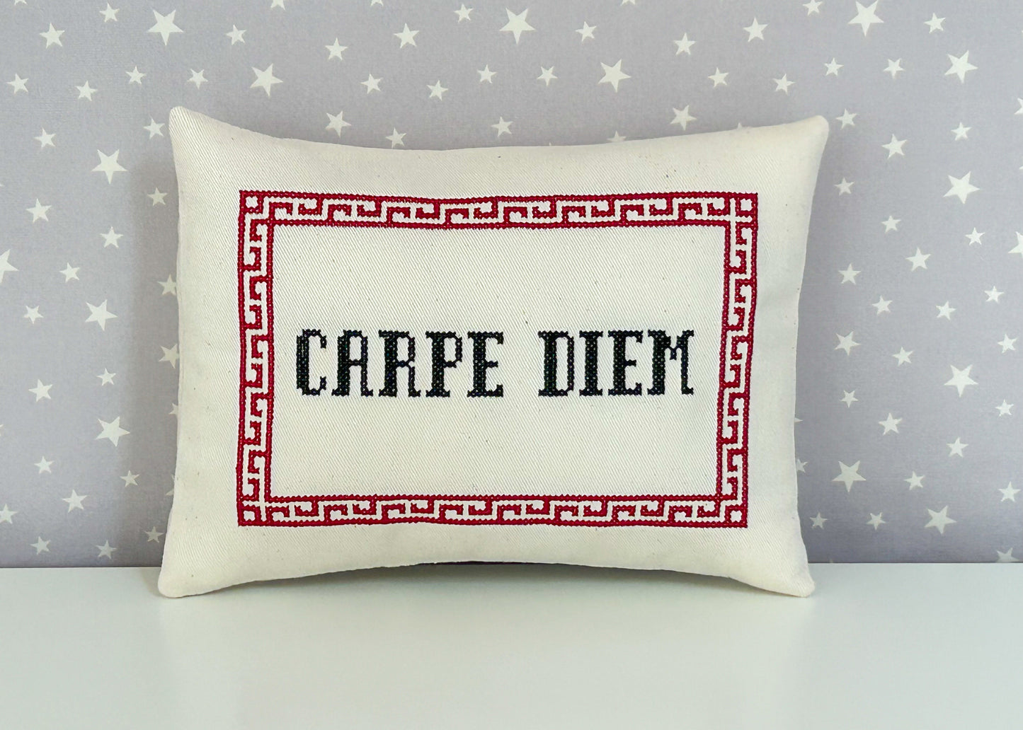 Decorative pillow with 'CARPE DIEM' text on a star-patterned background