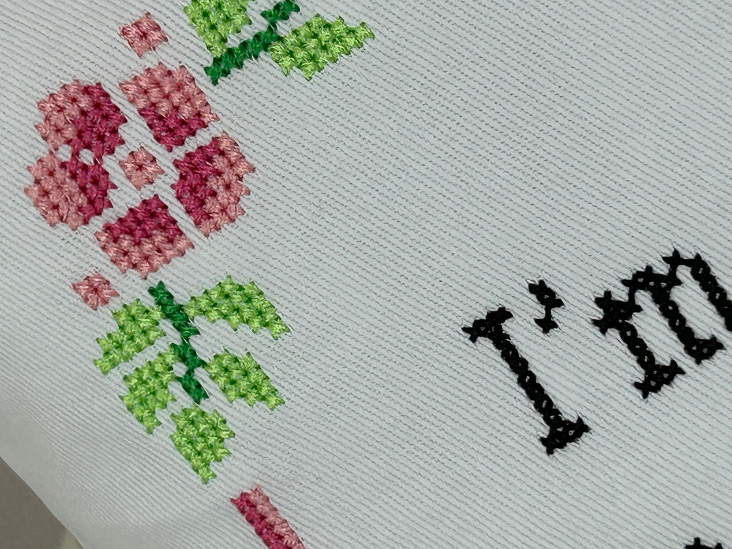Cross-stitched fabric with flowers and 'I love' text