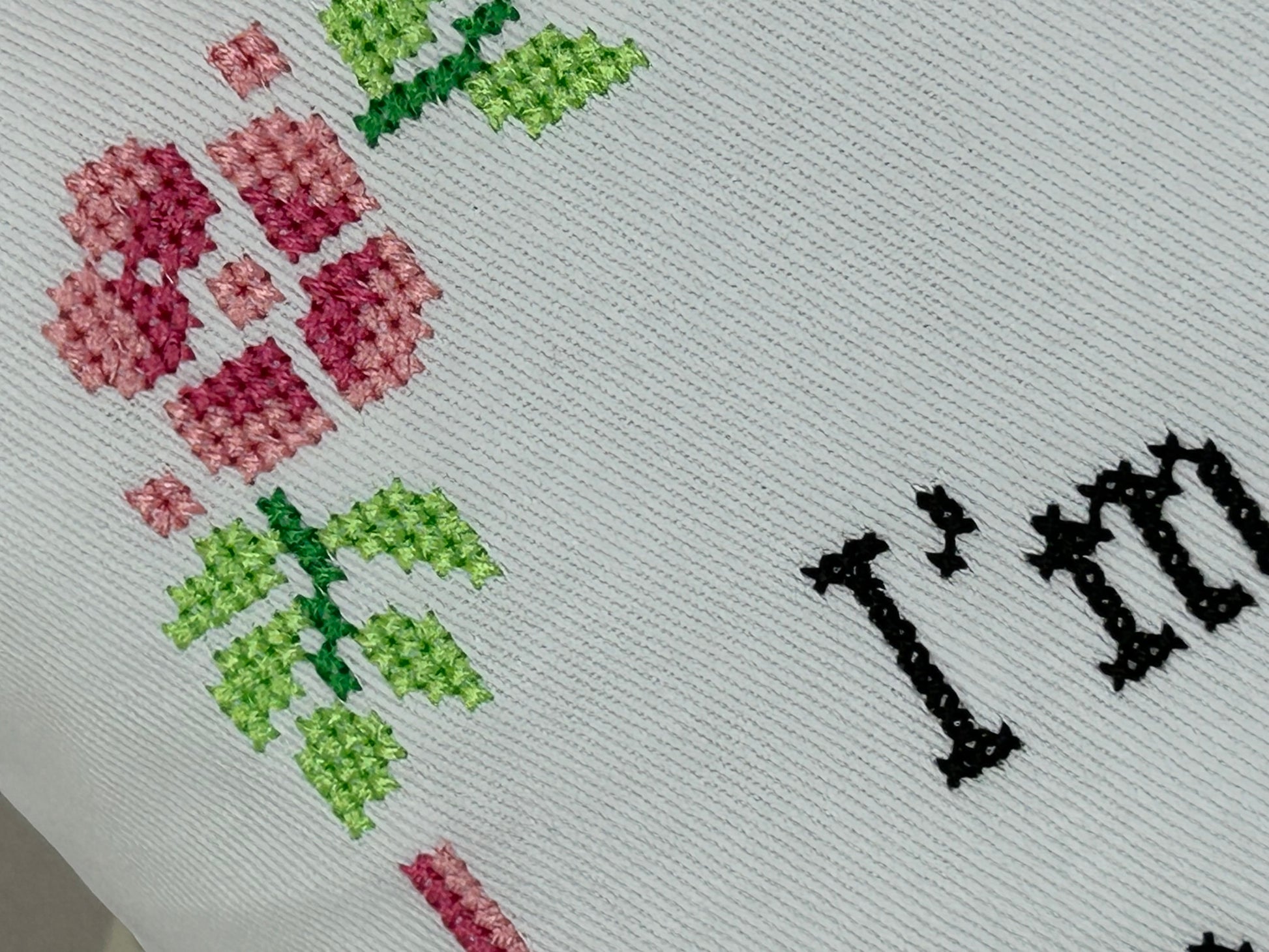 Cross-stitched fabric with flowers and 'I love' text