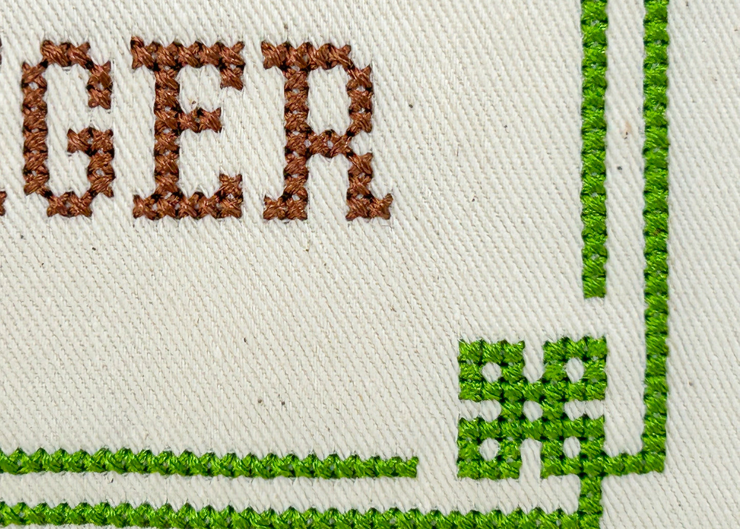 Embroidered text on fabric with a green border