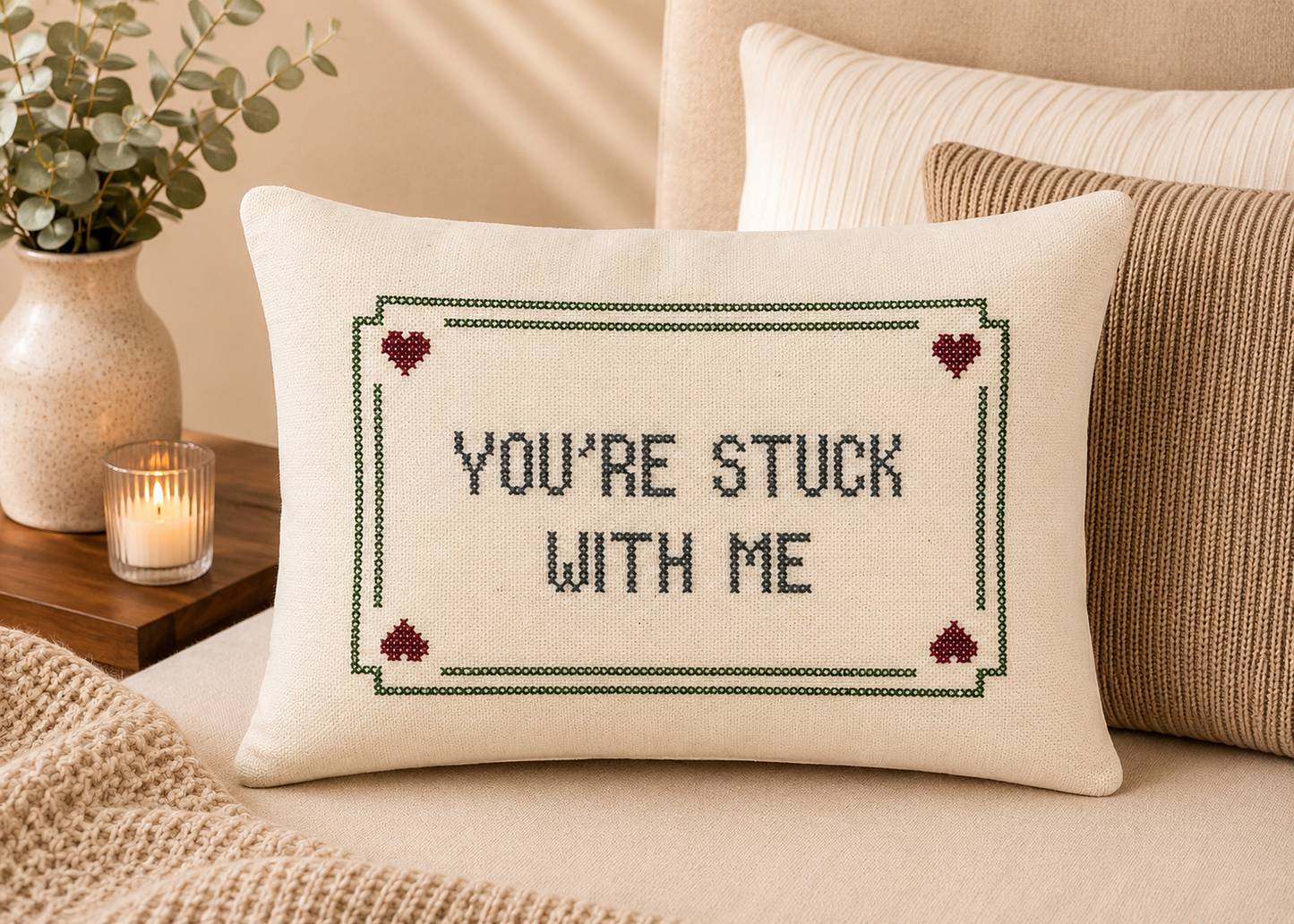 Decorative pillow with 'You're Stuck with Me' text on a bed.