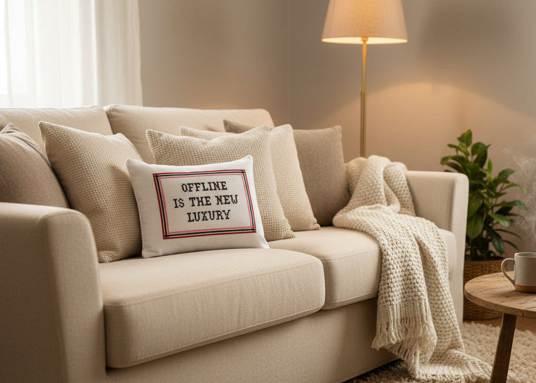 Beige sofa with decorative pillows and a blanket in a cozy living room setting.