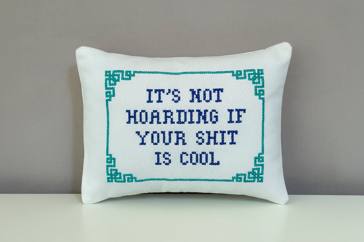 Decorative pillow with cross-stitched text on a star-patterned background