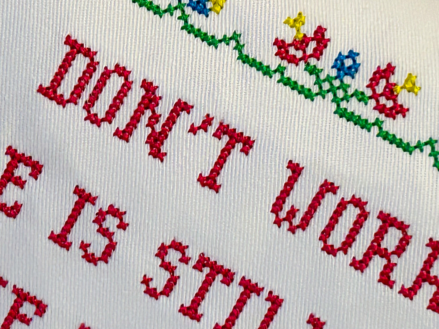Cross stitch embroidery text in red with red and blue flowers